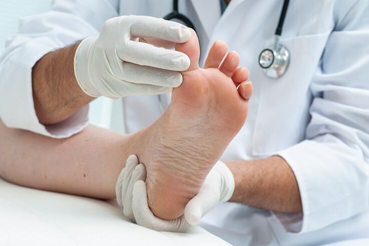Ο δερματολόγος εξετάζει τα πόδια του ασθενούς